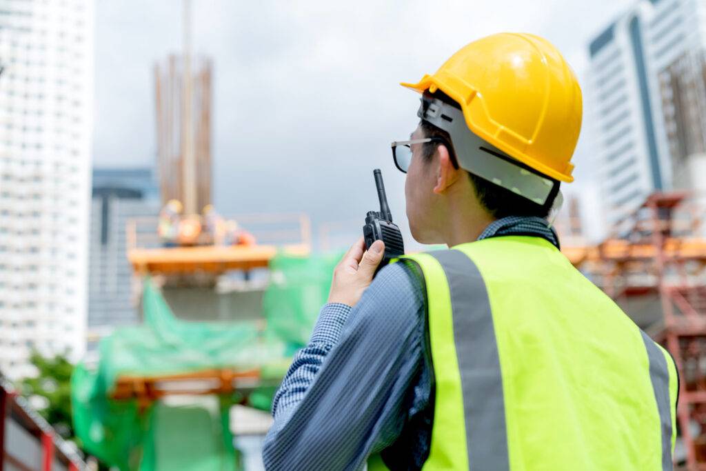 Construction worker with a walkie-talkie on site.