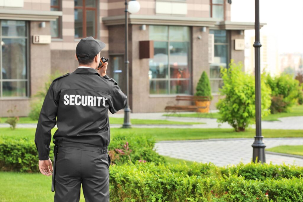 Security guard monitoring an outdoor area near a building.