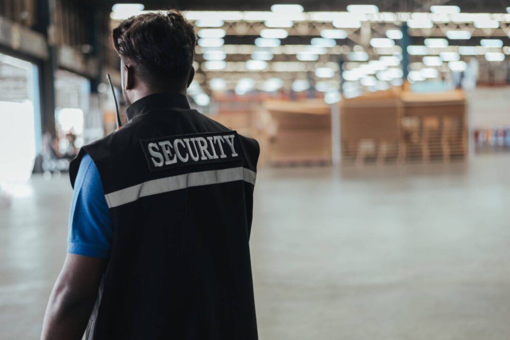 Security personnel monitoring a warehouse interior.